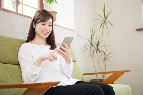 自宅のソファで相談内容を確認する女性